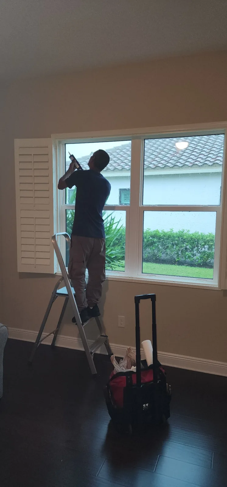 Technician working on window repair inside home